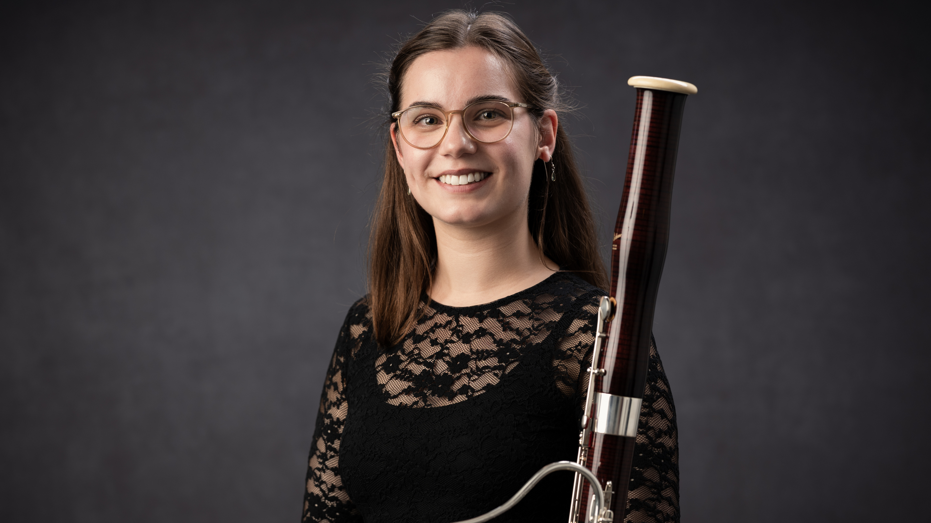 Mia Quist smiling at the camera holding a musical instrument